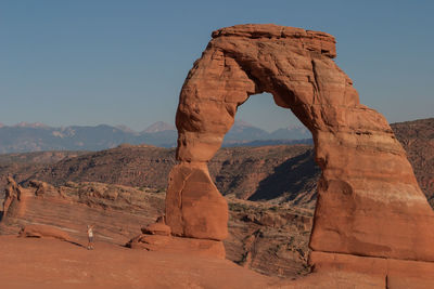 Man standing by rock formation at arches national park