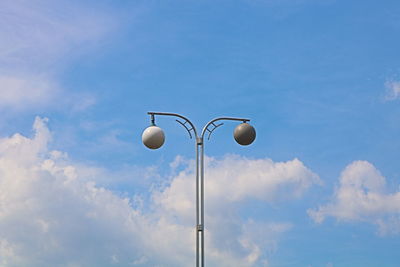 Low angle view of street light against blue sky