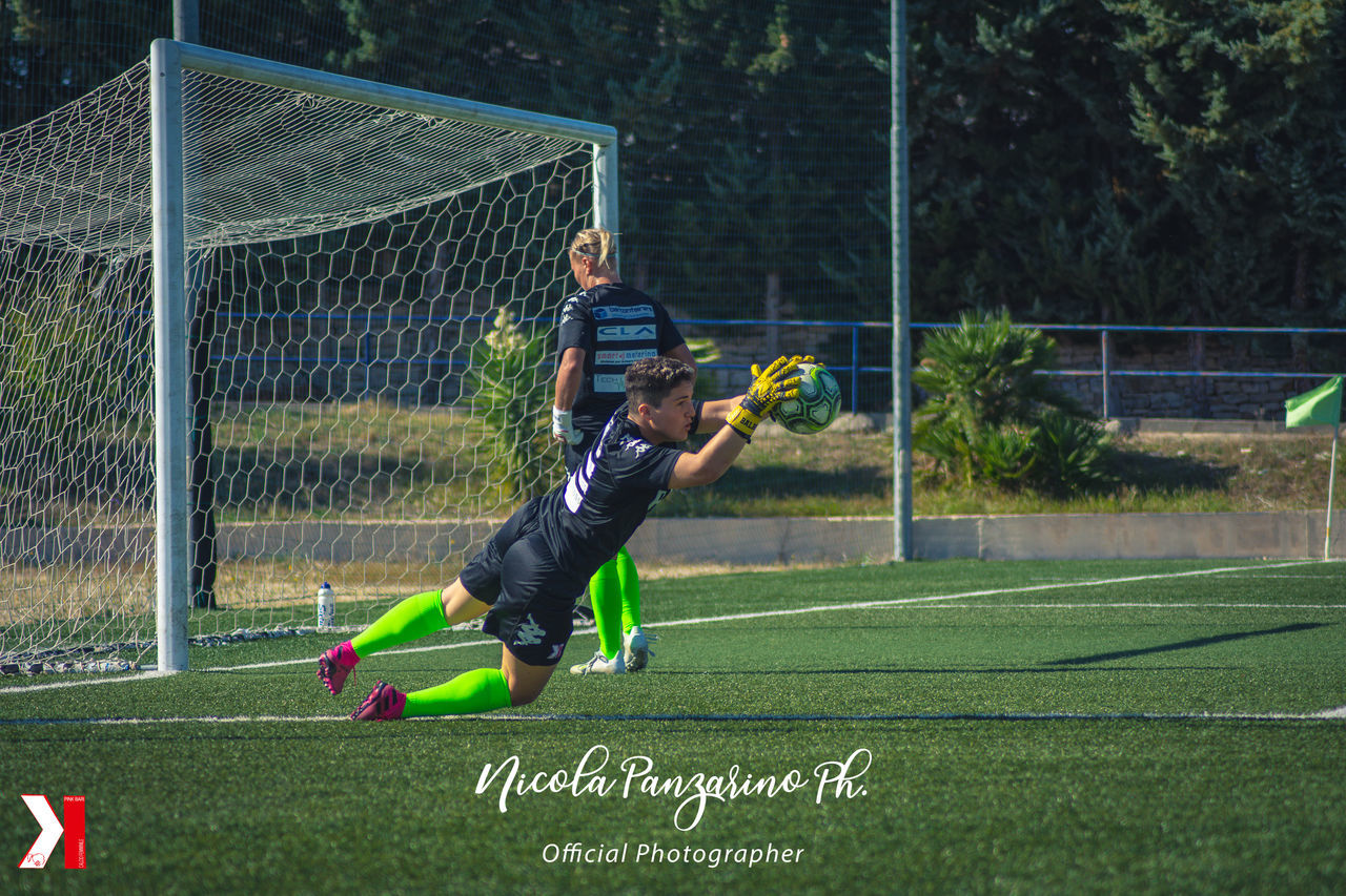 WOMAN PLAYING SOCCER BALL ON GRASS