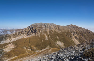 Scenic view of mountains against clear blue sky