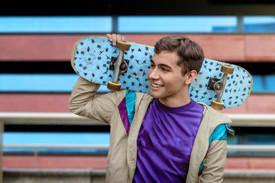 A teenager skateboarder. male teenager with a skateboard wearing casual clothing. 