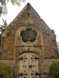 Low angle view of clock on building against sky