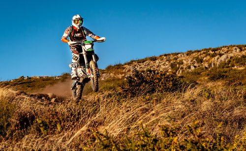 Man riding motorcycle on land against sky