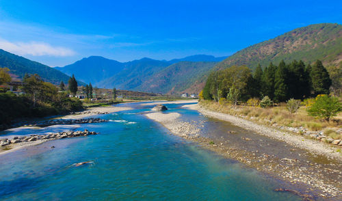 Scenic view of sea and mountains against blue sky