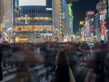 People walking on illuminated road at night