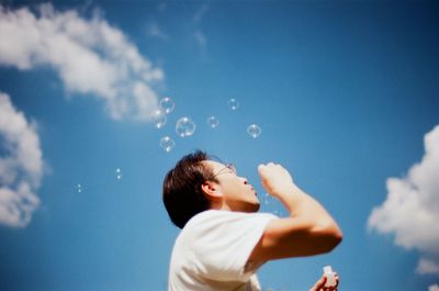 Low angle view of boy jumping against clear sky