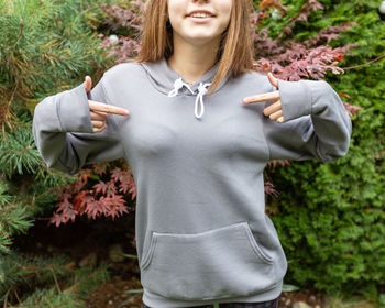 Young woman standing by plants