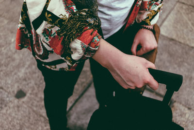 Midsection of woman holding luggage at railroad station