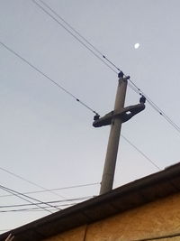 Low angle view of telephone pole against sky