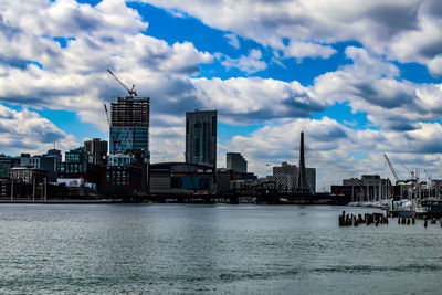 Modern buildings by sea against sky