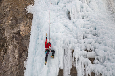 Woman climbs cliff at ice park in lake city, colorado