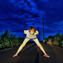 Woman standing by road against sky