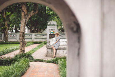 Woman seen through arch in park