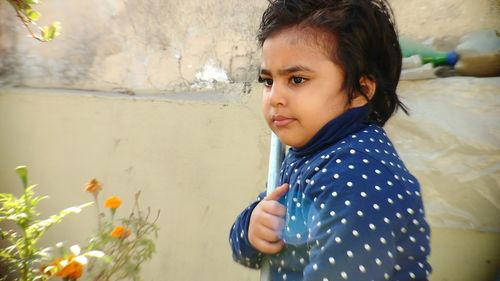 Close-up of girl standing against wall