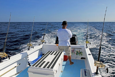 Rear view of man on sea against clear sky