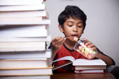 Portrait of a smiling young woman reading book