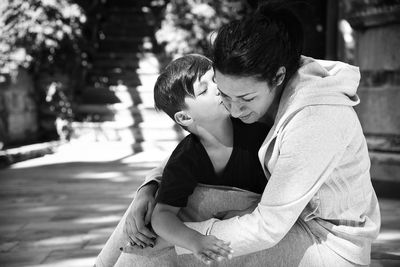 Son kissing mother at park