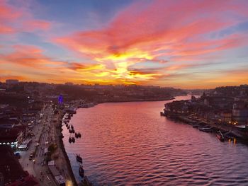 Scenic view of sea and buildings against sky during sunset