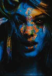 Portrait of young woman with multi colored painting