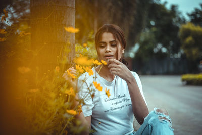 Full length of woman holding yellow flowering plant