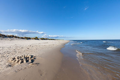 Scenic view of beach against blue sky