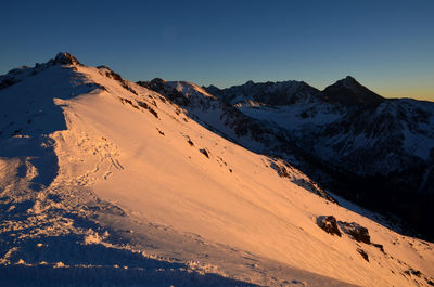 Scenic view of snowcapped mountains against sky during sunset