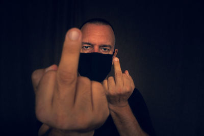 Portrait of man using mobile phone against black background