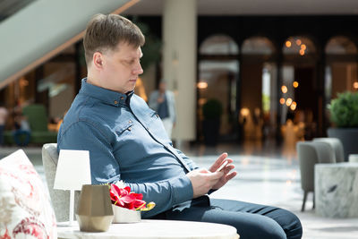 A man is waiting in a cafe waiting for his girlfriend for a date.