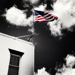 Low angle view of american flag against cloudy sky