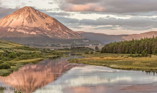 Scenic view of lake by mountains against sky