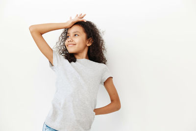 Portrait of young woman standing against white background