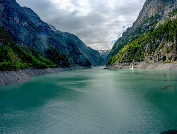 Scenic view of lake by mountains against sky