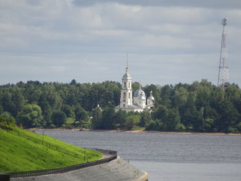 Tower amidst trees and buildings against sky