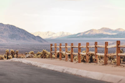 Road leading towards landscape and mountains against sky