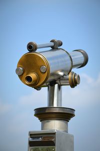 Low angle view of coin-operated binoculars against sky