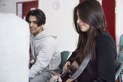 Teenagers attending guitar lesson