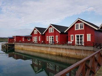 House by lake against sky