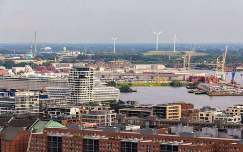 Aerial view of buildings in city against sky