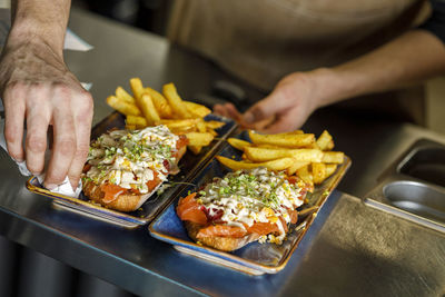 Chef cleaning serving dish at restaurant counter