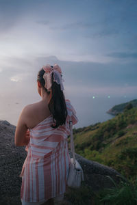 Young woman standing against mountain