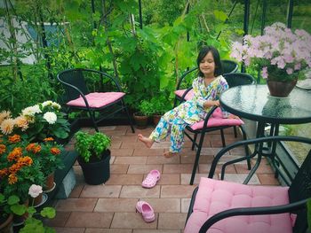 High angle view of cute girl sitting on seat in yard