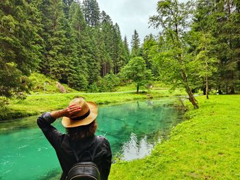 Rear view of woman standing by lake
