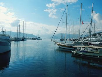 Sailboats moored in calm sea against sky