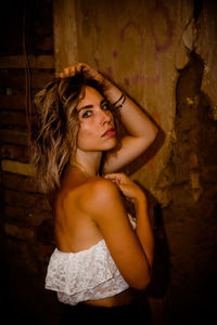 Portrait of woman standing against wall