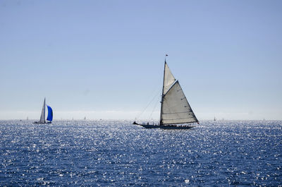 Sailboat in sea against clear sky