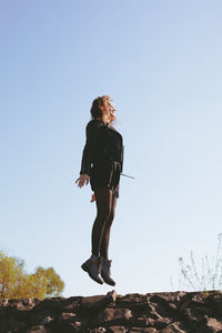 Low angle view of woman against clear sky