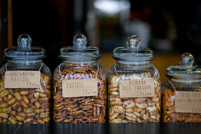 Close-up of various snacks in glass jars at shop