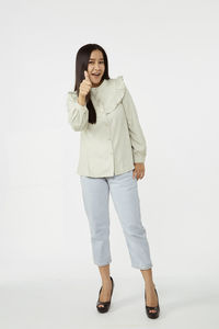 Portrait of a smiling young woman against white background