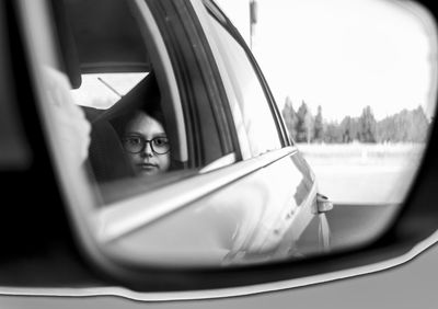 Reflection of car on side-view mirror with the kid inside