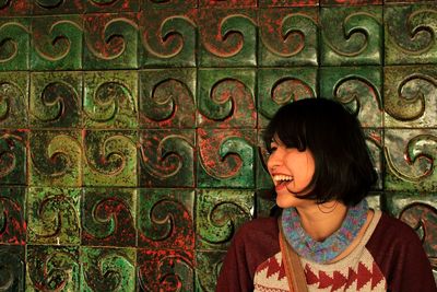 Young woman standing against wall